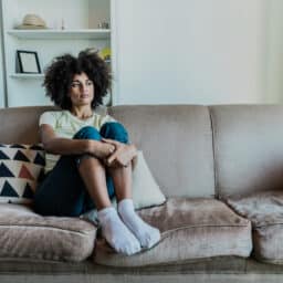 ad young woman looking away in the living room at home