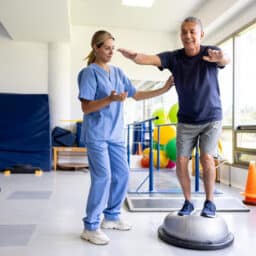 Man doing physical therapy exercises using a balance ball