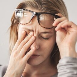 Tired woman rubbing her eyes.
