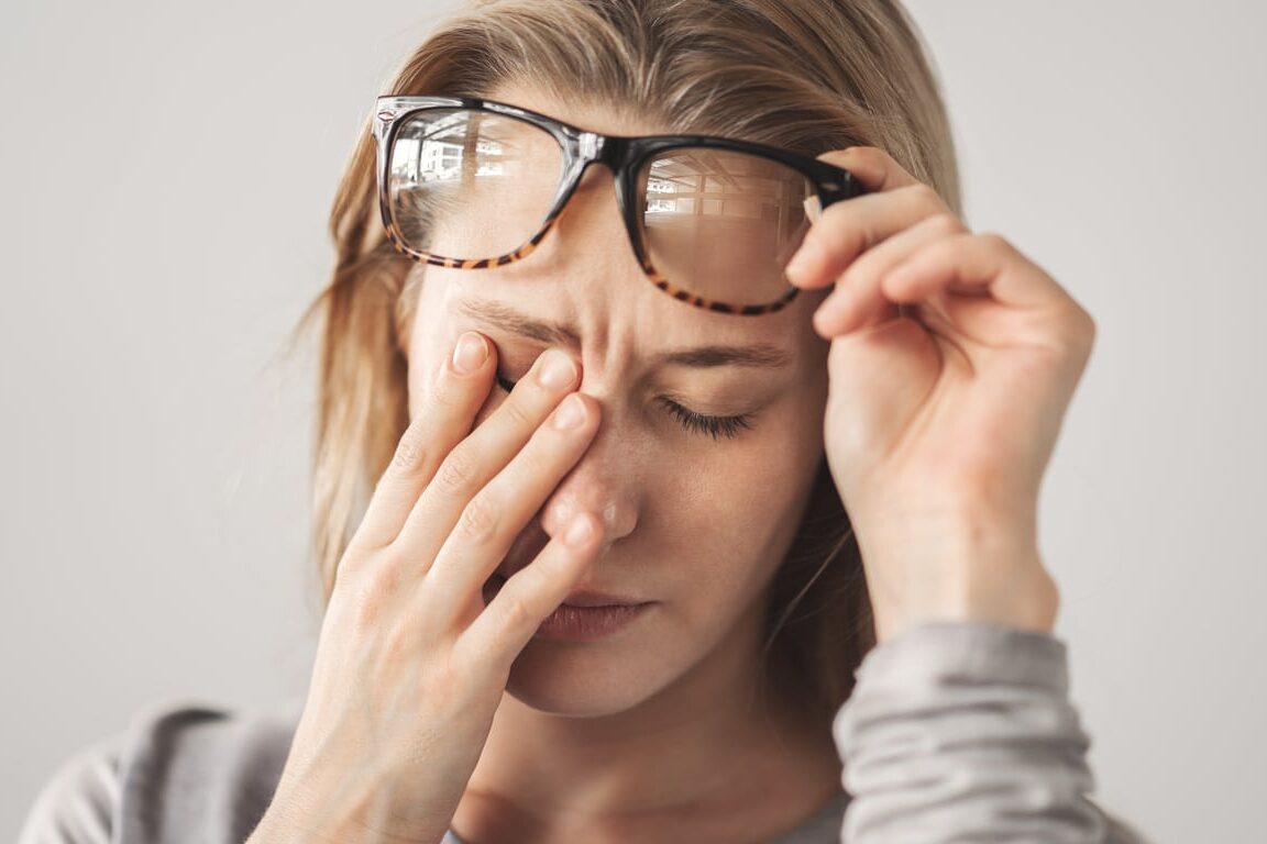 Tired woman rubbing her eyes.