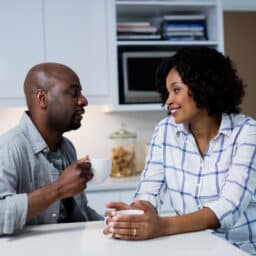 Couple sitting at their kitchen island and talking.